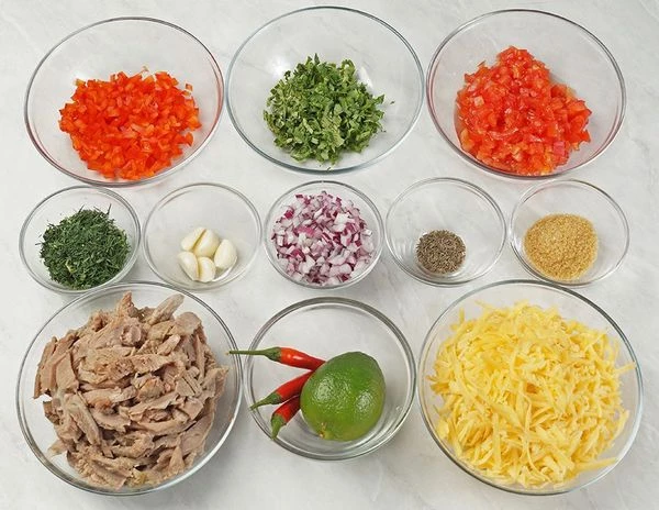 Отварить мясо индейки, нарезать соломкой. У сладкого перца удалить семена, нарезать мелким кубиком. Помидоры и красный лук нарезать мелким кубиком примерно 5х5 мм. Сыр натереть на крупной терке.