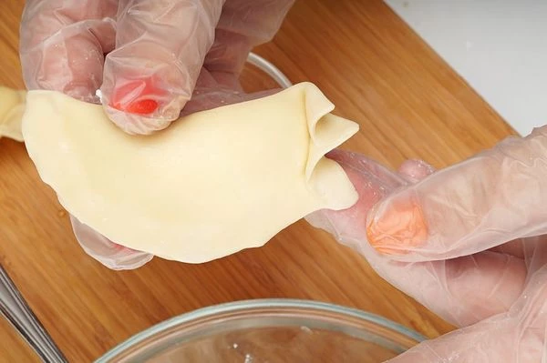 Начиная с одного края слепить тесто, фигурно подворачивая края.