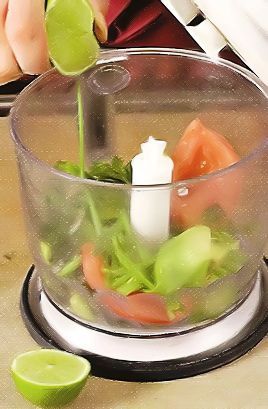 Приготовьте гуакамоле: помидор, зеленый лук и кинзу крупно порежьте. Авокадо разрежьте вдоль пополам, разъедините половинки, удалите косточку, очистите авокадо от кожуры.