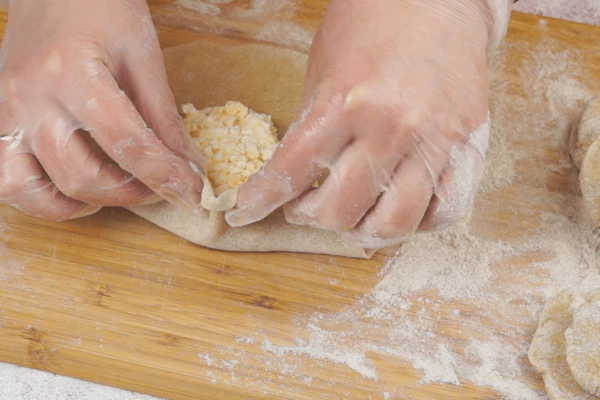  Раскатать тонко, в центр выложить начинку и защипать по краям. 