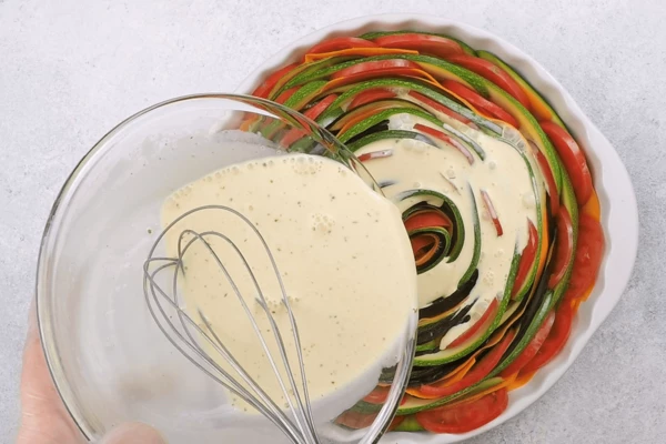  залить получившейся смесью овощи. Немного потрясти форму, чтобы заливка равномерно распределилась. Сверху посыпать натертым сыром и поставить в разогретую до 180С духовку на 40-45 минут. Овощи должны остаться немного альденте. Если не любите хрустящие овощи, можно увеличить время приготовления на 10-15 минут.