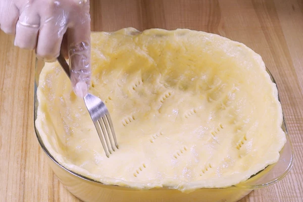 Готовое тесто распределить по форме для выпекания. Сделать проколы по всему периметру теста. 