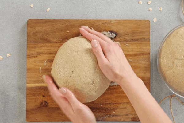 Затем тесто разделить на 2 равных части. Сформировать шарики из теста, выложить на противень, смазанный маслом или форму для хлеба.