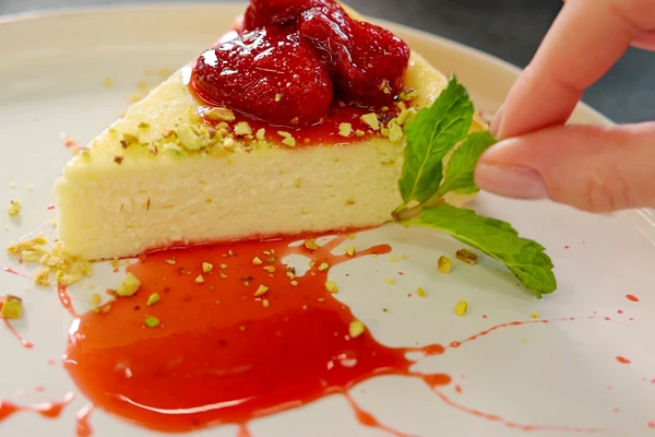 Сверху выложить чизкейк. Оформить фисташками и мятой. 
