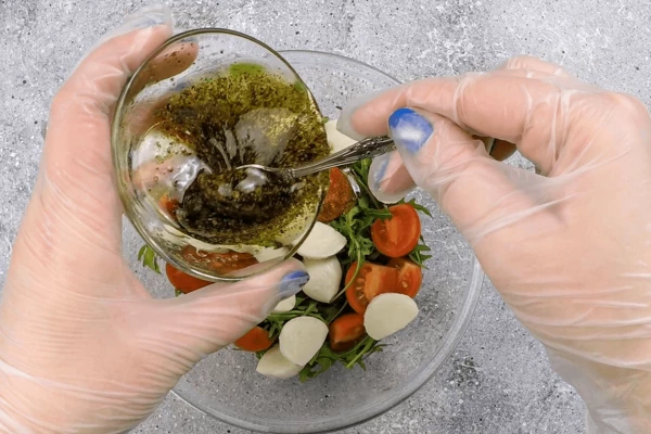 В чашке смешать рукколу, сыр, помидоры, добавить заправку (если планируется не сразу есть салат, то заправку можно добавить при подаче, полив сверху, иначе зелень опустится и промокнет). 