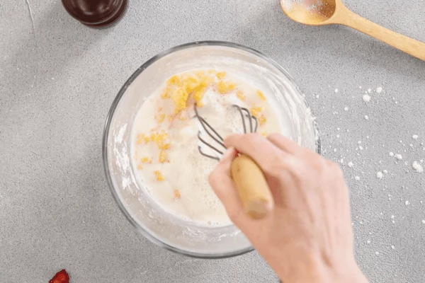 Для крема молоко нагреть почти до кипения. Влить часть горячего молока в яично-сахарную смесь, перемешать.
