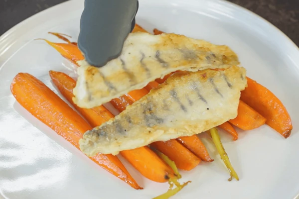 На тарелку для подачи выложить морковь и филе судака. 