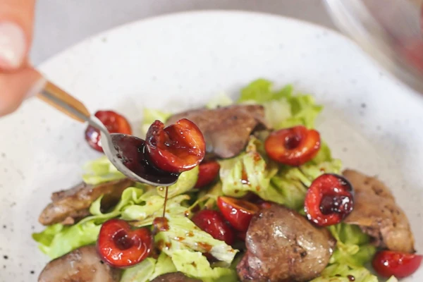 На блюдо для подачи выложить листья салата, маринованную черешню и обжаренную печень.