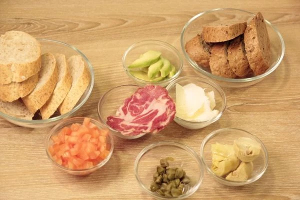 Багет нарезать наискосок, толщиной 1-1,5см. Сбрызнуть оливковым маслом, посолить, поперчить.