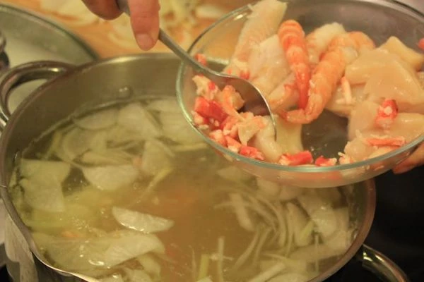 Добавить лук и редьку, довести до кипения и добавить морепродукты.