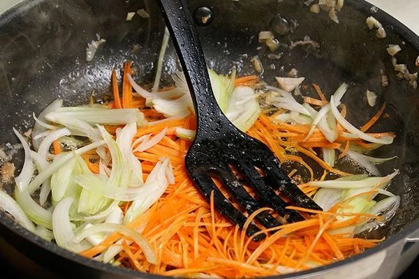 Не меняя сковороды, обжарить лук, морковь и чеснок.