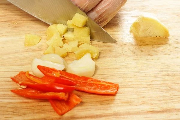 Нарезать имбирь, перец чили и чеснок небольшими кусочками и добавить к томату.