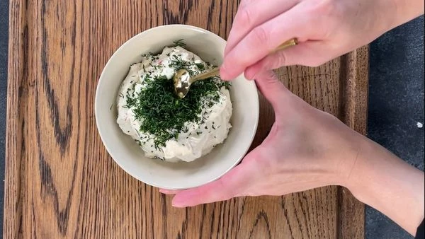 Творожный сыр смешать с нарезанным укропом.