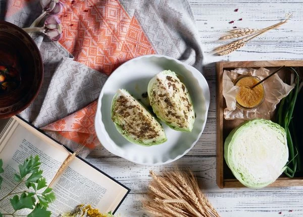 Капусту вымыть, разрезать пополам. Выложить в форму для запекания, полить маслом Конфи, посолить. Поставить в разогретую до 200 градусов духовку на 30-40 минут. 
