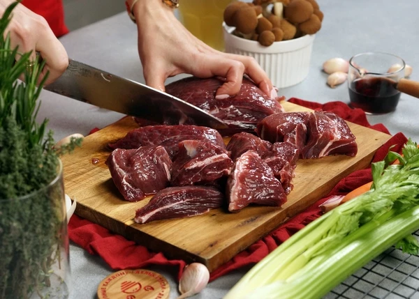 Говяжьи щечки разморозить, очистить от пленок и крупных жил, нарезать крупными кусками. 