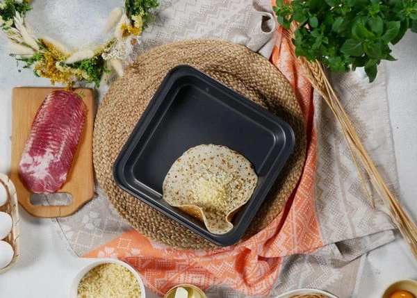 Блин слегка разогреть, смазать мягким сливочным маслом, выложить в форму для запекания, посыпать сыром. 