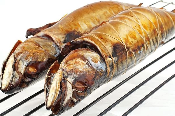 С готовой скумбрии аккуратно снять нить и убрать запеченные овощи из брюшка.