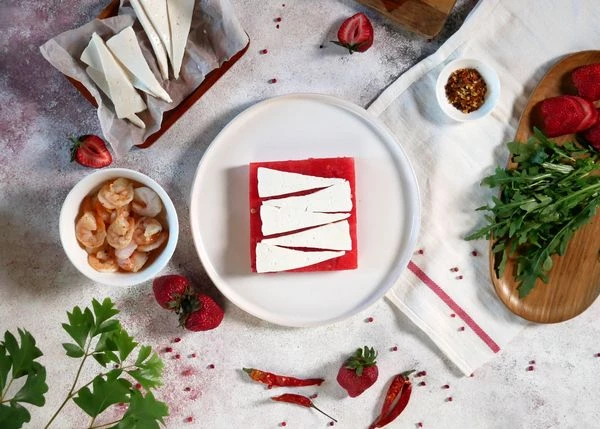 Брынзу нарезать слайсами. Выложить на арбуз.