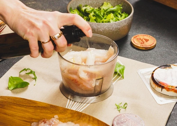 Минтай разморозить на нижней полке холодильника. Переложить в чашу блендера, добавить соль, масло. Измельчить. 
