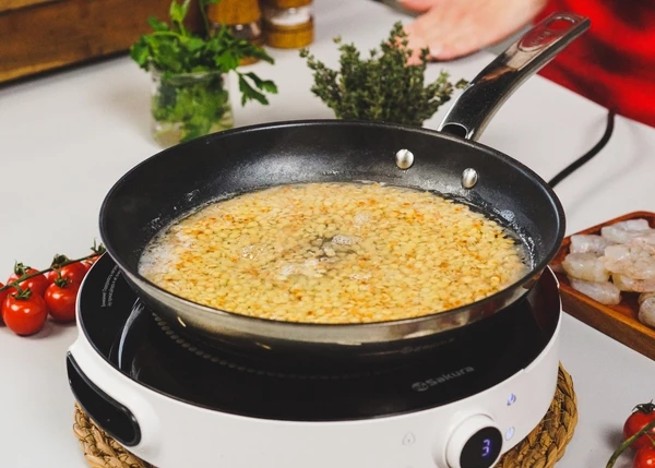 Залить кипящей водой, на 1,5-2 см выше птитима. Посолить, варить 15-17 минут на среднем огне. Переложить в глубокую тарелку. 