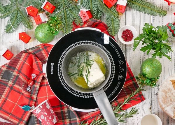 Сливочное масло переложить в сотейник, добавить листики розмарина и соль. Растопить на умеренном огне.