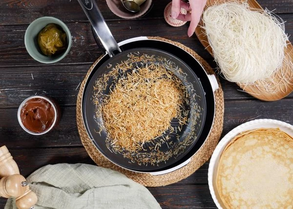 Тесто разморозить, поломать до размера вермишели, обжарить на масле до легкого карамельного цвета, дать остыть. 