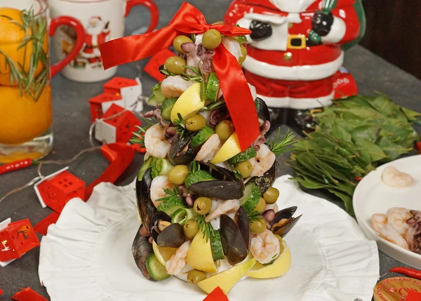 Морепродукты разморозить. Креветки и мини осьминоги отварить в течение 1,5-2 минут в подсоленной воде. Лимон нарезать на кусочки. Нанизать на зубочистки все ингредиенты. Оформить розмарином. Сразу подавать к столу. Приятного аппетита! 

