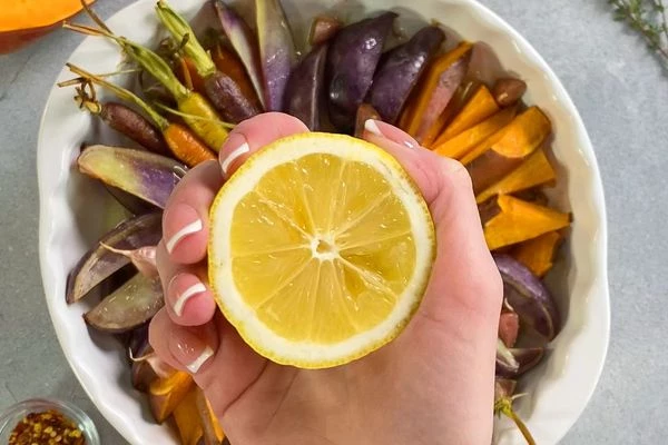 Овощи достать из духовки, сбрызнуть соком лимона. 