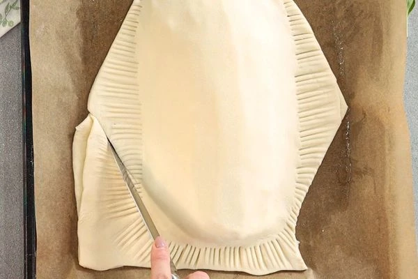 Придать форму рыбы. Ножом сделать насечки в виде чешуи, из оставшегося теста вырезать плавники. 
