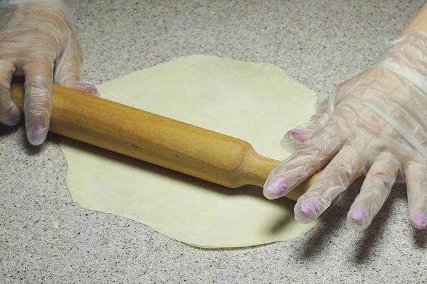 Готовые колобки из теста раскатать очень тонко скалкой в виде овала. 