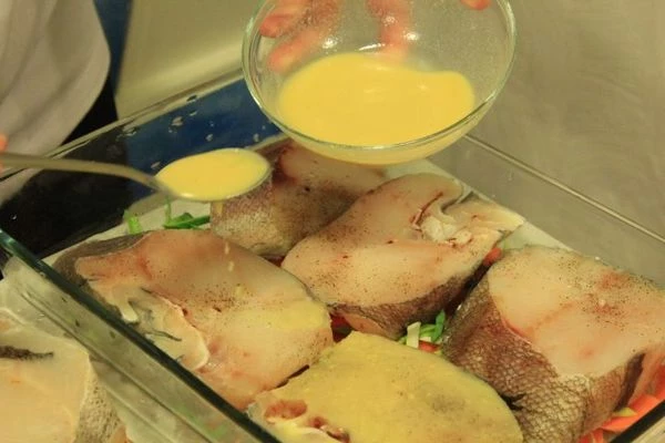 Сверху на овощи уложить стейки рыбы, залить смесью белого вина и горчицы.