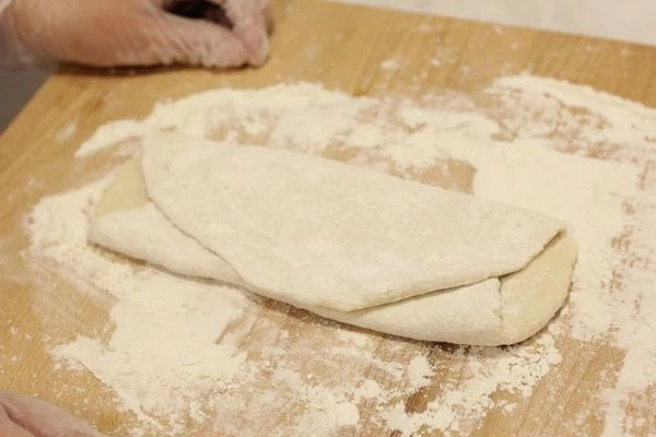 Раскатать получившееся тесто скалкой, затем сложить в трое, снова раскатать. Так повторить 3 раза.