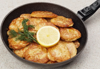 Драники обжарить на разогретой с растительным маслом сковороде, по 2-3 минуты с каждой стороны, до румяной корочки.