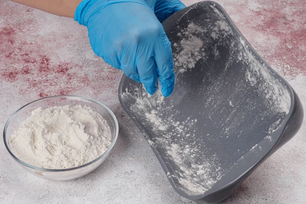 Стенки формы смазать сливочным маслом, обсыпать мукой.