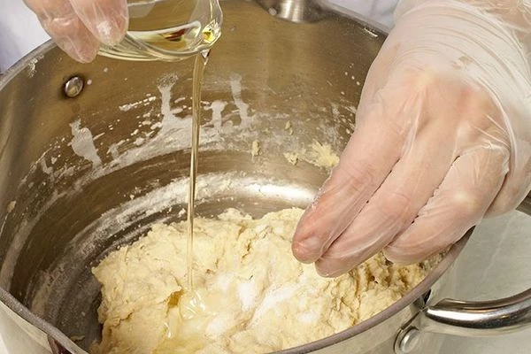 В готовое тесто влить растительное масло и хорошо вымесить.  Накрыть крышкой или чистым полотенцем, поставить в теплое место на 30-40 минут, периодически перемешивая.