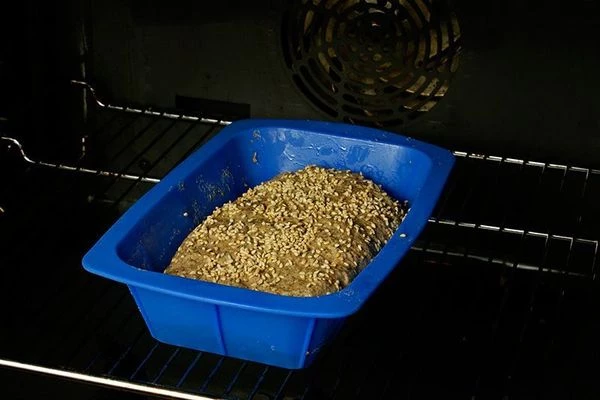 Выложить тесто в форму для выпекания, посыпать поверхность хлеба кунжутными семечками. Поставить в разогретую до 200С духовку на 40-50 минут. Выпекать до готовности.