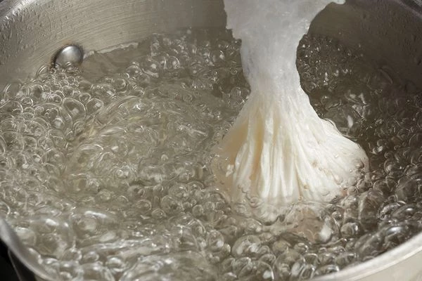 Закрутить пленку в виде кулечка, опустить яйцо в горячую воду, варить 3-4 минуты.