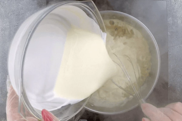  Пока булочки пекутся, готовим карамель. Для этого сахар расплавить в сотейнике с высокими бортами до жидкого состояния. Влить к растопленному сахару теплые сливки, быстро перемешивая венчиком карамель.