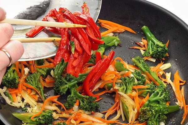 Затем добавить брокколи и перец, жарить еще 2-3 минуты.