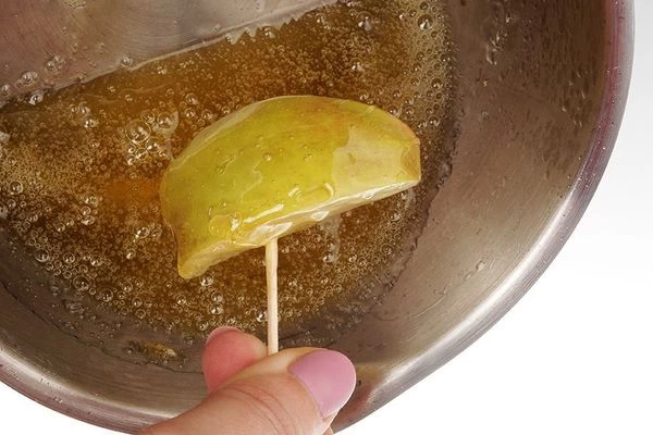 Яблоки наколоть на шпажки или зубочистки, обмакнуть в карамель.