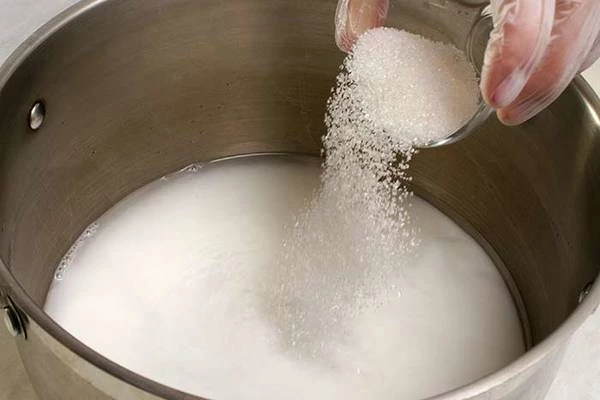 Смешать в большой кастрюле теплую воду, молоко и сахар.