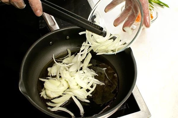 На разогретой с оливковым маслом сковороде обжарить лук 2-3 минуты, затем добавить морковь, жарить до золотистого цвета.