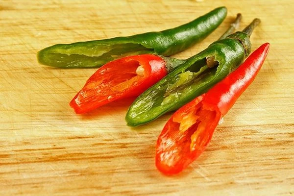 Перец чили разрезать наискосок пополам, удалить семечки.