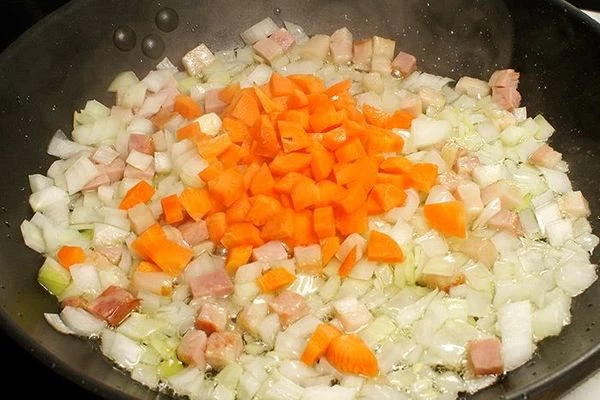 Затем добавить морковь, обжарить до мягкости овощей.