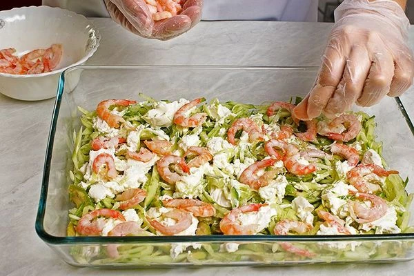  На сыр выложить слегка отваренные и нарезанные  креветки.