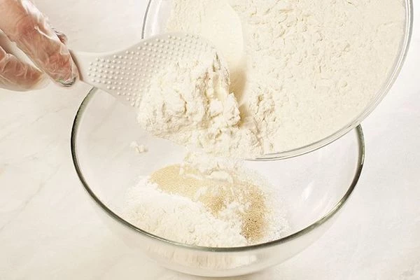 Смешать в миске муку, сахар (2 ст. л.), дрожжи, соль, яйца.