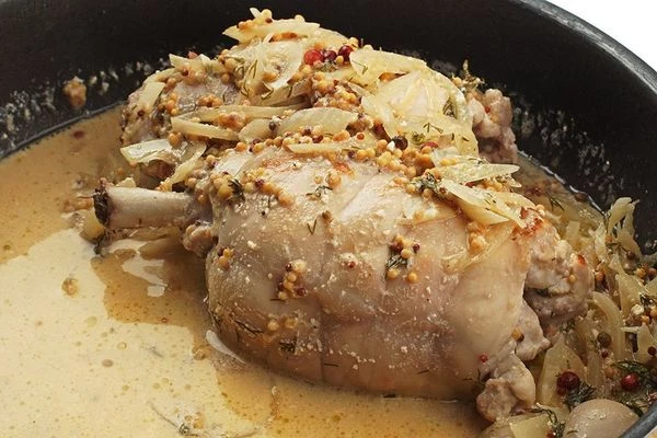 Затем добавить к луку ножки кролика, влить вино и сливки, тушить 30-40 минут до готовности мяса. Добавить мелко нарезанную зелень, снять с огня