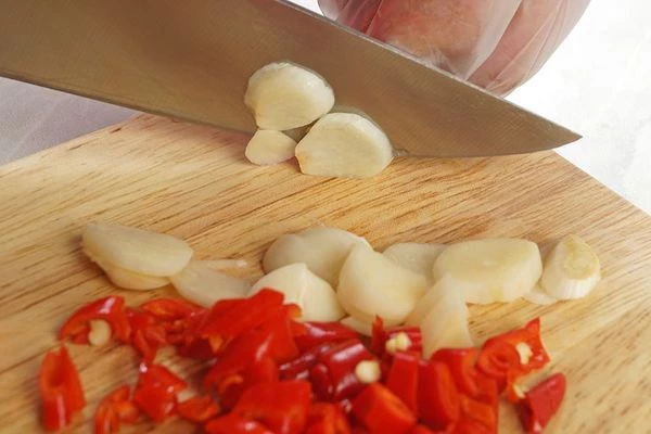 Приготовьте острую пасту: для этого перец чили очистить от семян. Нарезать мелко чеснок и перец..