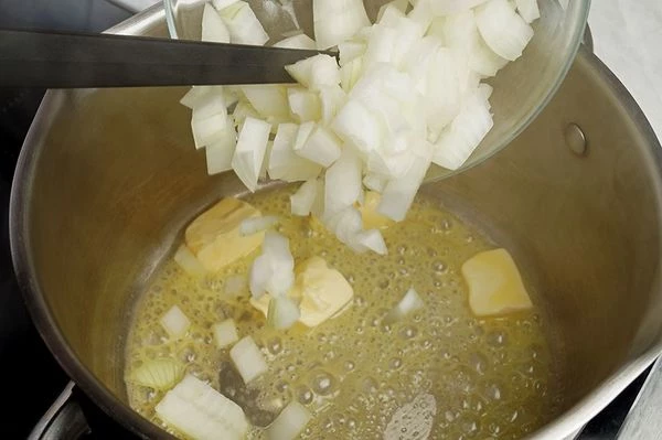 В кастрюльке разогреть сливочное масло, обжарить лук до золотистого цвета 2-3 минуты.