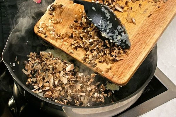 На разогретой с оливковым маслом сковороде обжарить лук до прозрачности, потом добавить  нарезанные грибы.
